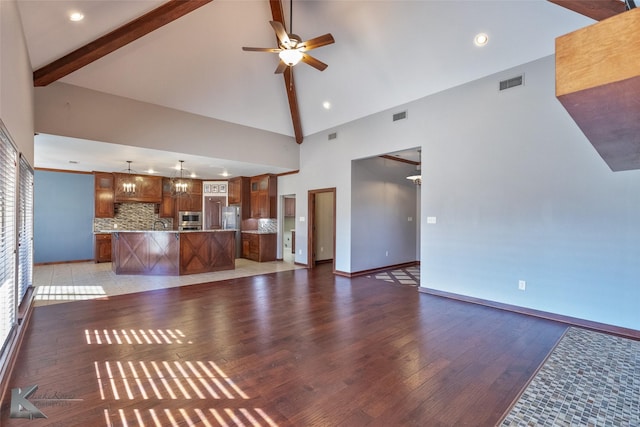 unfurnished living room featuring light hardwood / wood-style flooring, beam ceiling, ceiling fan with notable chandelier, and high vaulted ceiling