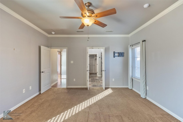 unfurnished bedroom featuring crown molding, a spacious closet, ceiling fan, and carpet