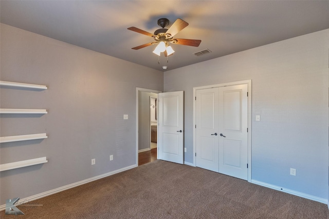 unfurnished bedroom with dark colored carpet, ceiling fan, and a closet