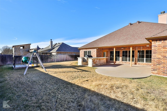 view of yard with an outdoor kitchen, a playground, and a patio