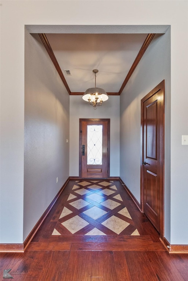 entryway with an inviting chandelier and ornamental molding