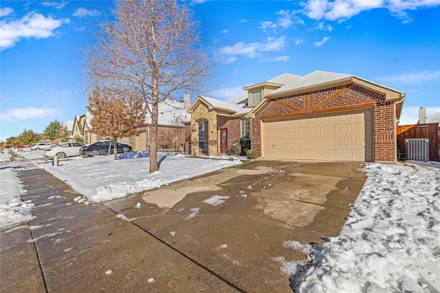 view of front of home with a garage and central AC