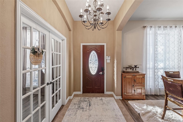 entrance foyer featuring french doors and a notable chandelier