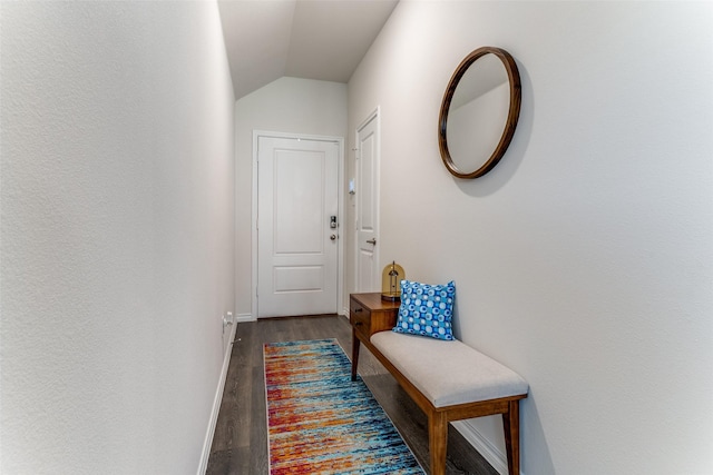 corridor with dark hardwood / wood-style floors and vaulted ceiling