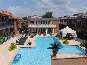 rear view of house featuring a gazebo, a community pool, and a patio area