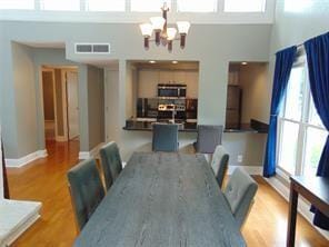 dining space featuring a chandelier, a high ceiling, and a healthy amount of sunlight