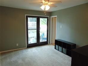 spare room with light carpet, french doors, and ceiling fan