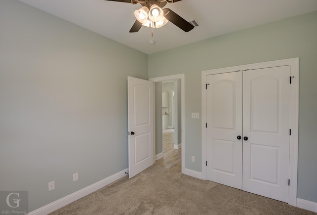 unfurnished bedroom featuring ceiling fan, a closet, and light carpet