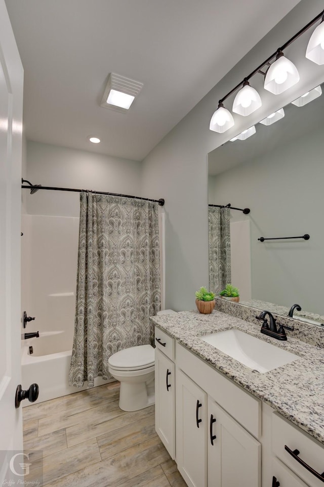 full bathroom with vanity, hardwood / wood-style floors, shower / bath combination with curtain, and toilet