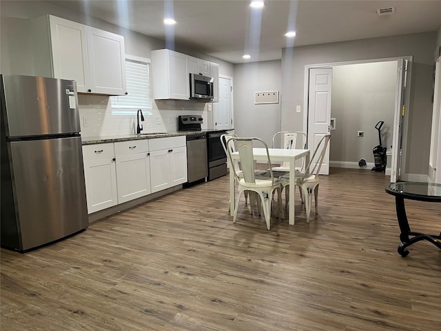 kitchen featuring white cabinets, stainless steel appliances, and dark wood-type flooring