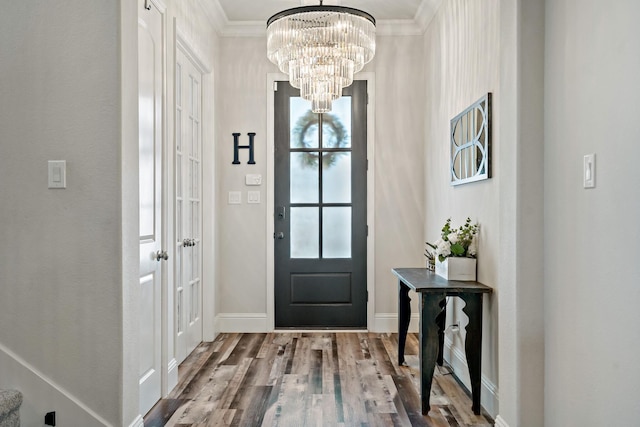 entryway featuring hardwood / wood-style floors, an inviting chandelier, and ornamental molding