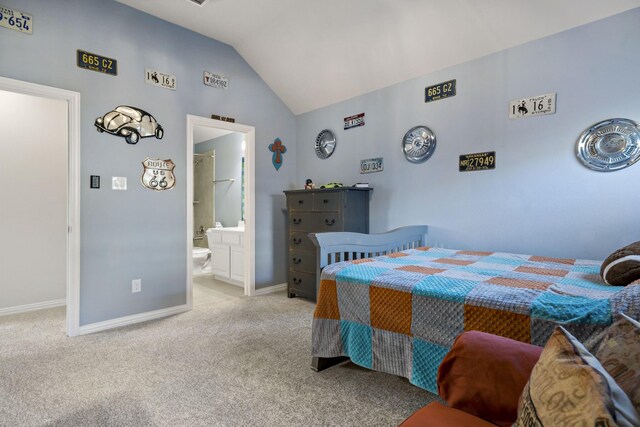 bedroom featuring ensuite bathroom, light colored carpet, and lofted ceiling