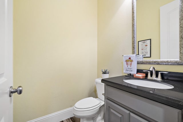 bathroom with hardwood / wood-style floors, vanity, and toilet