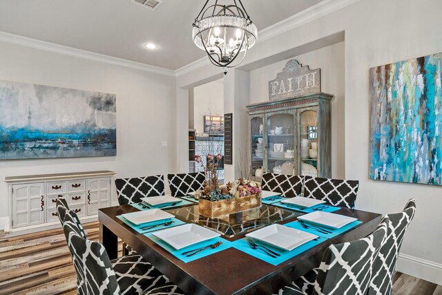 dining room featuring a notable chandelier, wood-type flooring, and crown molding