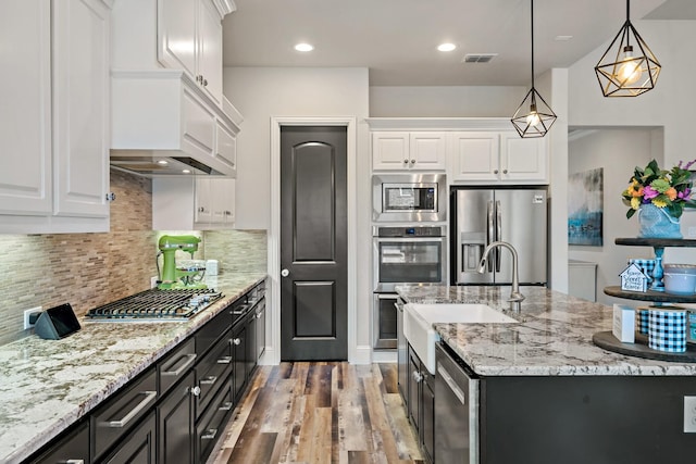 kitchen with white cabinets, pendant lighting, and stainless steel appliances