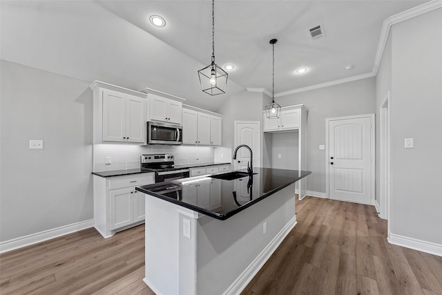 kitchen featuring white cabinetry, a center island with sink, vaulted ceiling, and appliances with stainless steel finishes