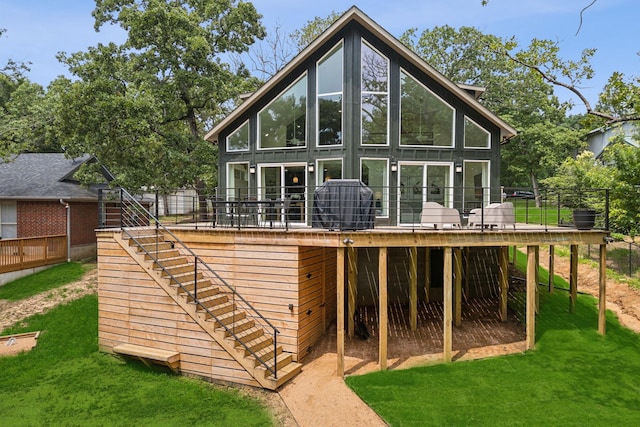 rear view of property with a yard, a deck, and a sunroom