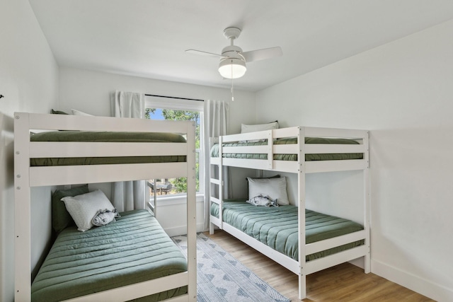 bedroom featuring multiple windows, wood-type flooring, and ceiling fan