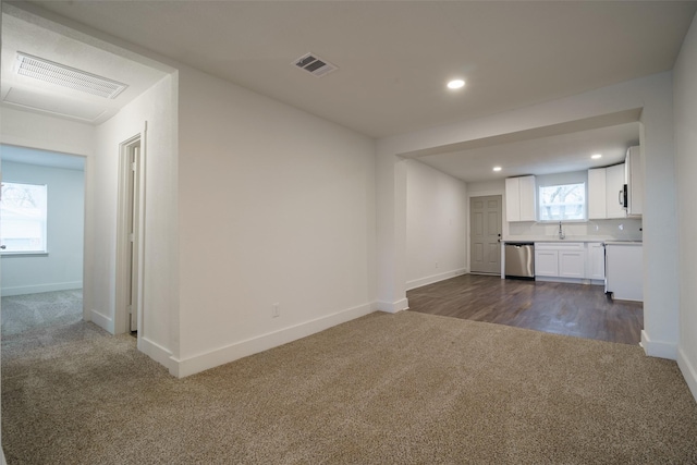 unfurnished living room featuring sink and dark carpet