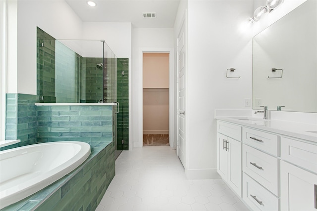 bathroom featuring tile patterned flooring, vanity, and shower with separate bathtub