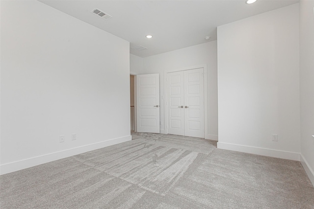 unfurnished bedroom with light carpet and a closet