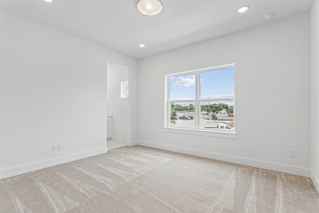 unfurnished room featuring light colored carpet