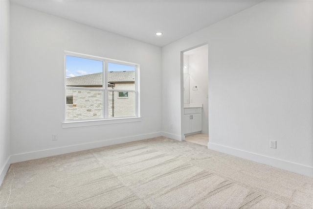 unfurnished room featuring light carpet