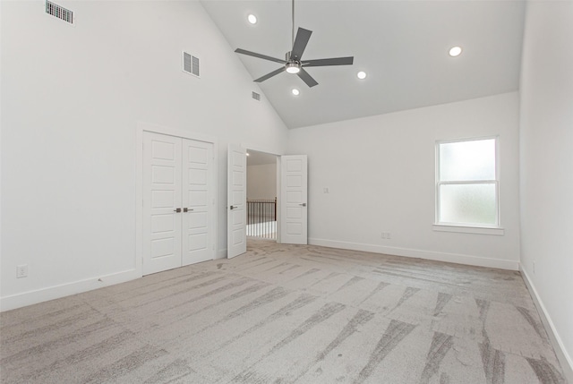 unfurnished bedroom featuring light carpet, high vaulted ceiling, and ceiling fan