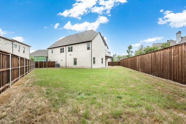 rear view of house featuring a yard and cooling unit