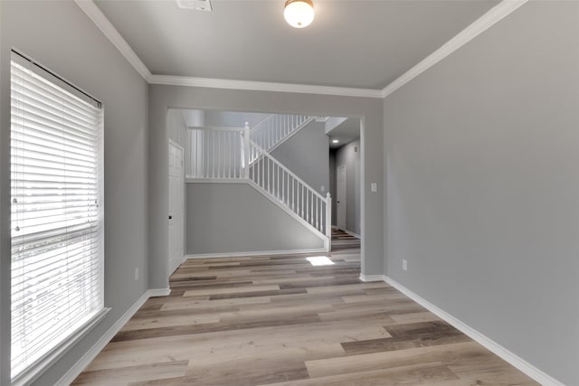 interior space with crown molding and light hardwood / wood-style flooring