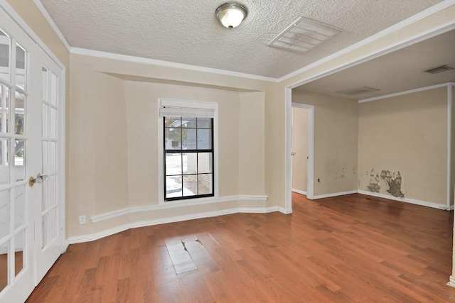 unfurnished room with wood-type flooring, a textured ceiling, and ornamental molding