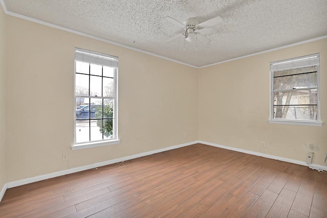 spare room featuring hardwood / wood-style floors, ceiling fan, ornamental molding, and a textured ceiling