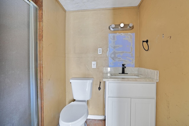 bathroom featuring a shower with door, vanity, and toilet