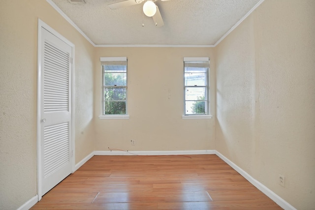 unfurnished bedroom featuring multiple windows, ceiling fan, ornamental molding, and light wood-type flooring