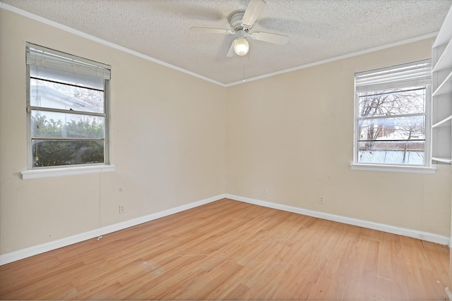 unfurnished room with plenty of natural light, ornamental molding, a textured ceiling, and light wood-type flooring