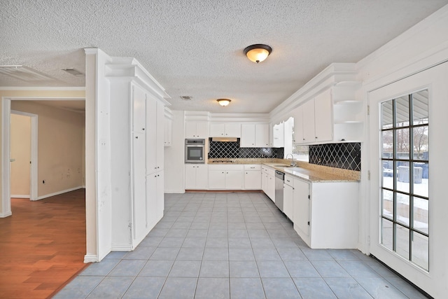 kitchen with white cabinetry, sink, a healthy amount of sunlight, stainless steel appliances, and backsplash