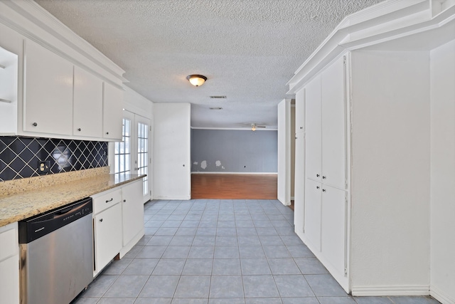 kitchen featuring ceiling fan, dishwasher, light tile patterned flooring, decorative backsplash, and white cabinets