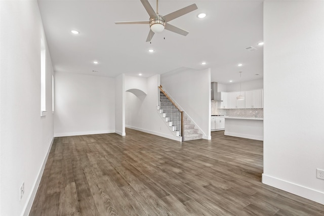 unfurnished living room featuring dark hardwood / wood-style floors and ceiling fan