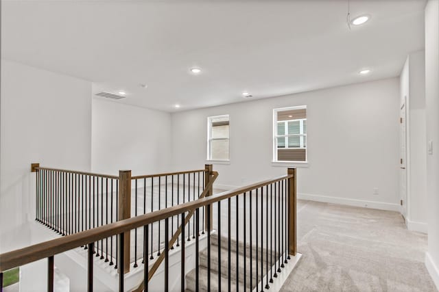 hall featuring light colored carpet