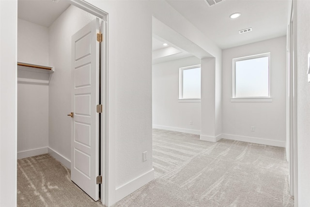 hallway featuring light colored carpet