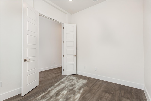 empty room with dark hardwood / wood-style flooring