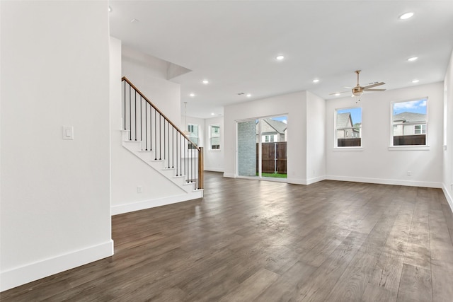 unfurnished living room featuring ceiling fan, dark hardwood / wood-style floors, and a wealth of natural light