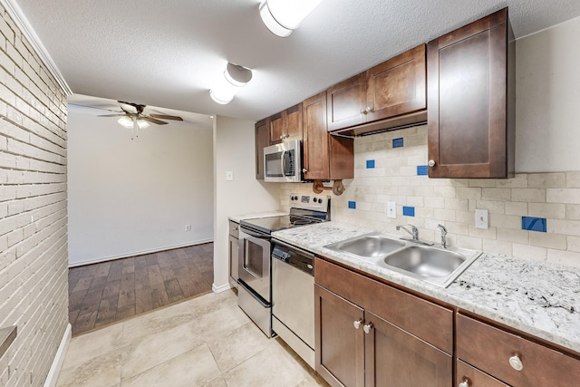 kitchen featuring appliances with stainless steel finishes, a textured ceiling, ceiling fan, and sink