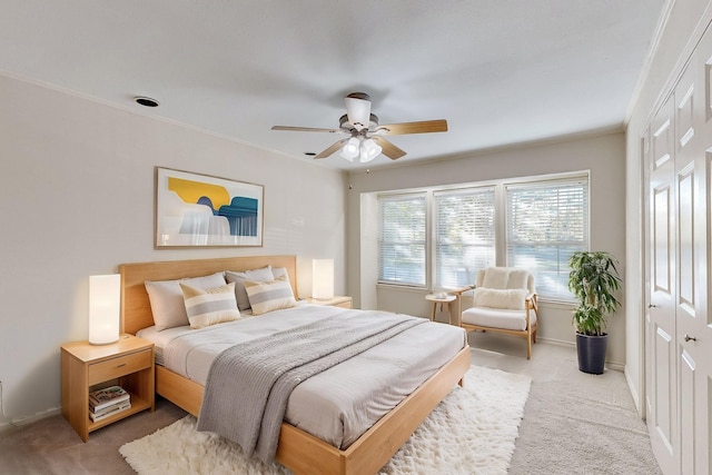 bedroom featuring carpet, ceiling fan, crown molding, and a closet