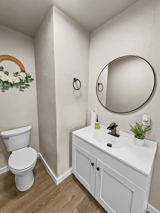 bathroom featuring vanity, toilet, and wood-type flooring