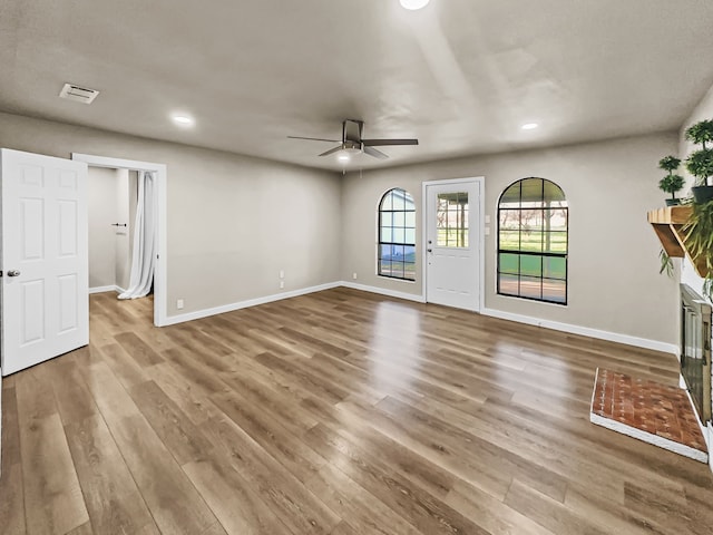 unfurnished living room with ceiling fan and hardwood / wood-style floors