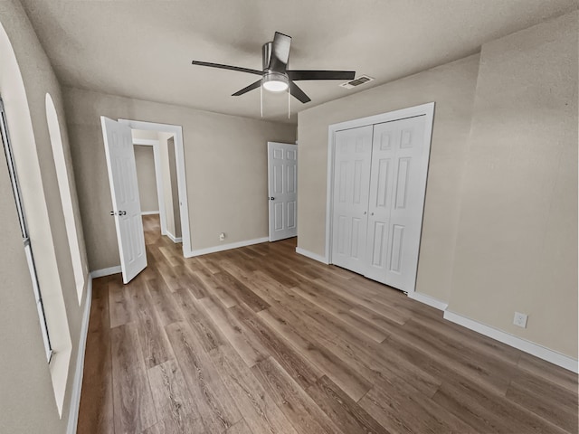 unfurnished bedroom featuring a closet, ceiling fan, and hardwood / wood-style floors