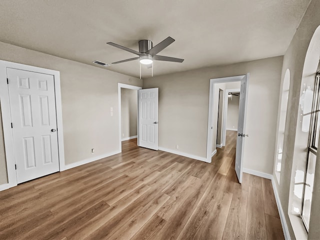 unfurnished bedroom featuring light wood-type flooring and ceiling fan