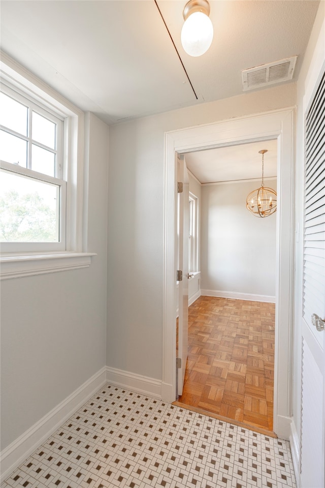 interior space with light parquet floors and an inviting chandelier