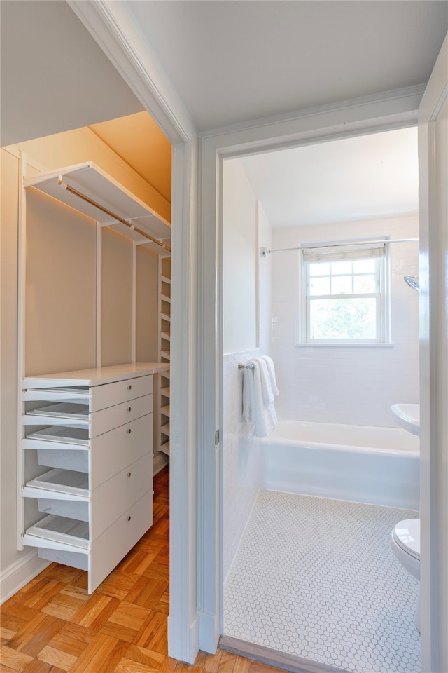 bathroom featuring parquet flooring, shower with separate bathtub, and toilet